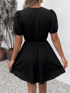 Vue arrière d'une robe noire à manches bouffantes avec taille haute élastique et coupe en A