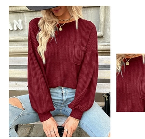 Close-up of burgundy waffle knit texture and front pocket on women's long sleeve top