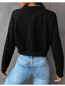 Rear view of black raglan sleeve sweatshirt with ribbed cuffs and gold chain necklace