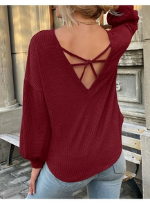 Detail showing the backless V-neck design and criss-cross straps of the waffle knit top