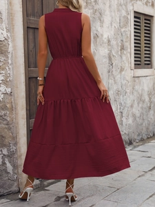 Détail de la robe sans manches bordeaux à volants montrant le tissu plissé et l'ourlet