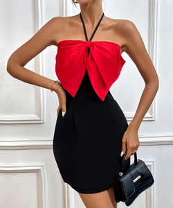 Close-up of elegant halter dress with oversized red satin bow and black bodycon skirt