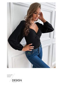 Detail of black V-neck bodysuit featuring an elegant twist knot and long sleeves