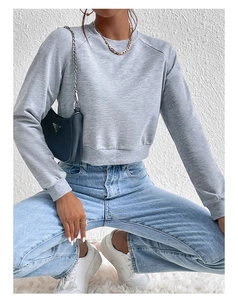 Detail of grey cropped long sleeve sweatshirt featuring ribbed cuffs and crew neck finish