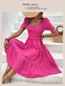 Detail of pink smocked tiered dress with square neckline and ruffled hem for summer