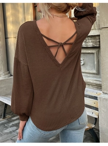 Detail of dark brown waffle knit top featuring a backless V-cut with crisscross straps
