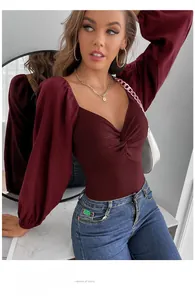 Detail view of burgundy V-neck bodysuit with front twist knot and ribbed texture fabric