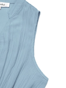 Détail de la robe sans manches bleu clair à col en V montrant le tissu gaufré et couture