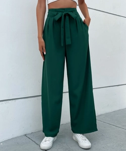 Detail of high-waist dark green wide-leg trousers with elegant ribbon bow waistband tie