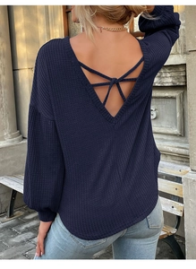 Detail of dark blue waffle knit top featuring a backless design with criss-cross straps