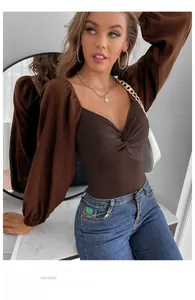 Detail of the V-neck twist front and brown rib-knit bodice with elegant puff sleeves
