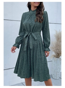 Dettaglio del collo alto a balze e del motivo a pois sul vestito verde scuro elegante