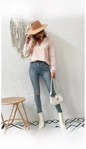 Detail of V-neck shirt with gold polka dots and delicate lace trim on pink fabric