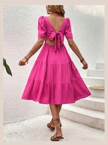 Detail of rose red backless dress with large bow-tie, puffed sleeves and cut-out waist