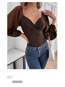 Detail of V-neck twisted front bodysuit with sheer lantern sleeves and ribbed knit body