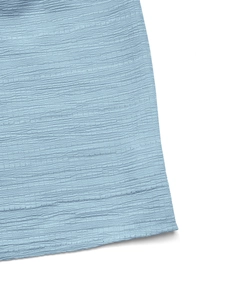 Vue macro du tissu froissé bleu clair pour robe d'été avec col en V et coupe en A