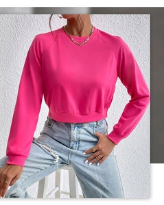 Detail of rose red cropped sweatshirt featuring ribbed cuffs and crew neck collar