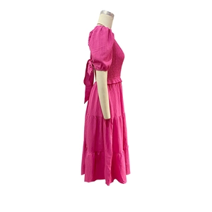 Detail of rose pink midi dress featuring tiered skirt and open back bow tie design