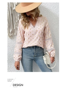 Detail of V-neck lace patchwork and gold foil polka dots on a pink long sleeve blouse