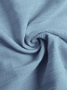 Détail du tissu bleu clair de la robe avec un motif de tissage gaufré haut de gamme