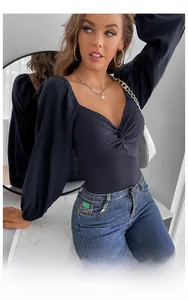 Close-up of deep V-neck knit bodysuit featuring a twisted knot detail and ribbed texture