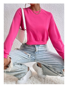 Detail of rose red cropped sweatshirt featuring ribbed cuffs and crew neck collar