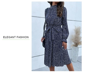 Dettaglio dell'abito midi a pieghe blu navy a pois con cintura in vita e collo alto