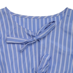 Détail de l'encolure rayée bleu et blanc avec un nœud décoratif élégant sur la robe