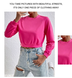 Close-up detail of hot pink cropped sweatshirt featuring ribbed crewneck and sleeve cuffs