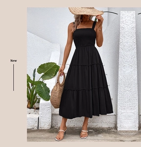 Détail d'une robe longue noire à volants et bustier froncé pour un style plage d'été