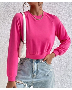 Close-up of hot pink crop top sweatshirt featuring ribbed crewneck and cuffs detail