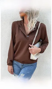 Outdoor shot of a brown drawstring hoodie with button neckline and raglan sleeves