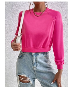 Detail of hot pink cropped sweatshirt with ribbed crewneck and raglan sleeves design