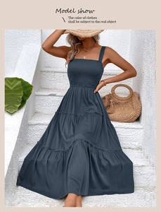 Détail des volants superposés et du bustier smocké sur une robe longue d'été bleu marine
