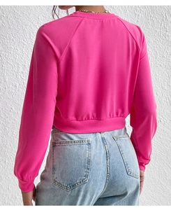 Rear view of cropped magenta pink sweatshirt featuring dropped shoulders and ribbed hem