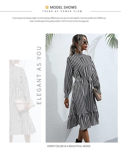 Detailed close-up of a striped long-sleeve dress with ruffled collar and gathered cuffs