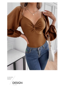 Close-up of brown V-neck bodysuit featuring twist-knot detail and stylish puff sleeves