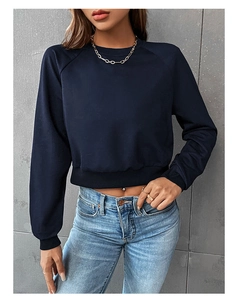 Detail of navy cropped sweatshirt with raglan sleeves and ribbed cuffs on female model