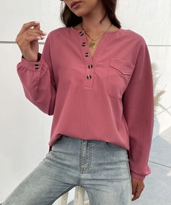Detail of dusty pink Henley blouse featuring textured fabric and tortoiseshell buttons