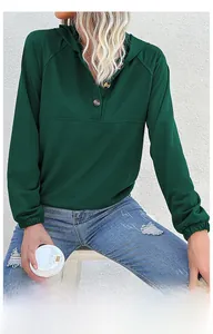 Dettaglio felpa con cappuccio verde scuro con scollo henley e polsini elastici