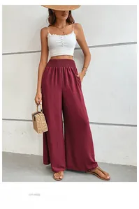 Detailed close-up of high-waist elastic smocked waistband on wine red wide leg trousers