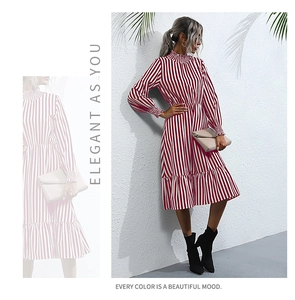 Detailed view of red and white vertical striped dress with elegant ruffle hem and mock neck