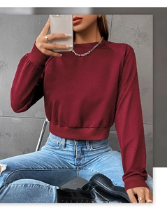 Detail view of burgundy cropped sweatshirt with ribbed cuffs and round neck style