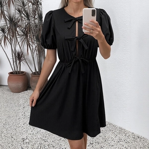 Robe noire élégante avec manches bouffantes, nœuds et découpes pour l'été chic