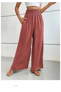 Detailed macro view of smocked elastic high waist and pocket on brick red flare pants