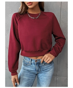 Detail of burgundy cropped sweatshirt featuring raglan sleeves and ribbed cuffs