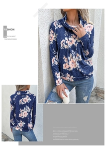 Dettaglio della felpa a dolcevita blu scuro con grandi motivi floreali rosa e coulisse bianche