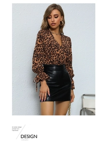 Close-up of leopard print V-neck top with drawstring cuffs and black PU leather skirt
