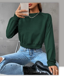 Detail of forest green cropped sweatshirt with ribbed hem and crew neck style