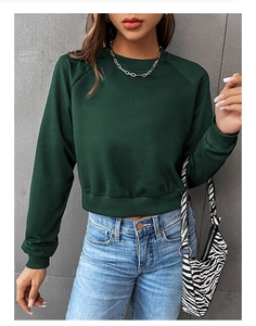 Detail of dark green cropped crewneck sweatshirt with raglan sleeves and ribbed cuffs